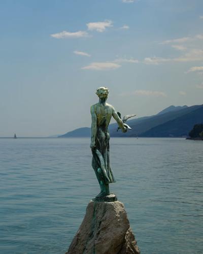Scenic view of the iconic Maiden with the Seagull statue in Opatija, Croatia, overlooking the Adriatic Sea.