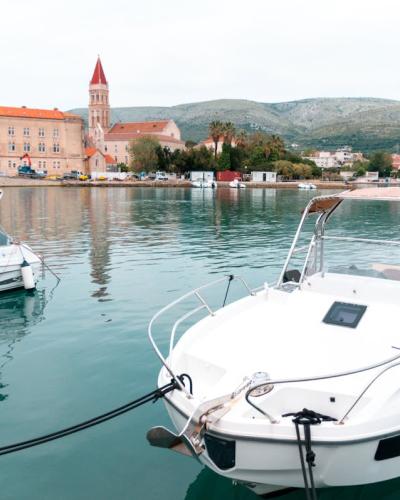 Tranquil scene of Trogir harbor with boats and historic architecture in Croatia.
