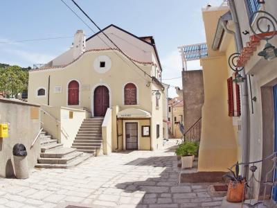 Sunlit alley in Krk, Croatia showcasing charming historic architecture and inviting atmosphere.