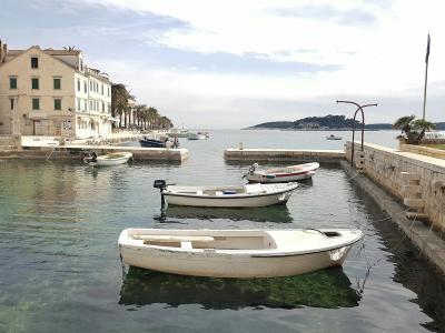 Peaceful harbor scene with docked boats and historic architecture in Hvar, Croatia.
