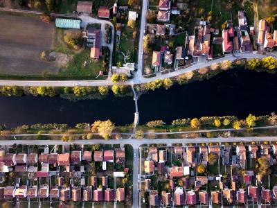 Aerial view of a neighborhood and river in Vinkovci, Croatia, showcasing houses and a bridge.