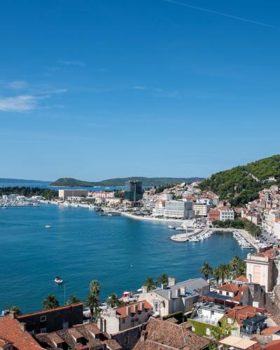 Stunning aerial photo of Split, Croatia showing the coastline, cityscape, and vibrant blue sea on a sunny day.