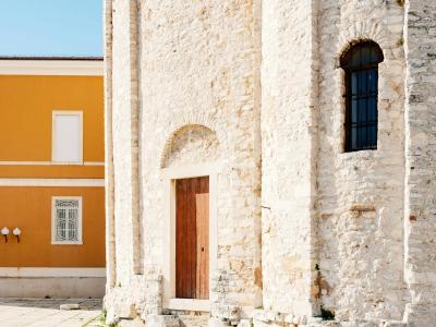 Detail of a stone church wall with historical architecture in Zadar.
