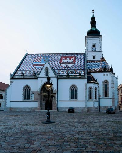 Stunning view of St. Mark's Church in Zagreb's historic square, featuring its vibrant tiled roof at dusk.