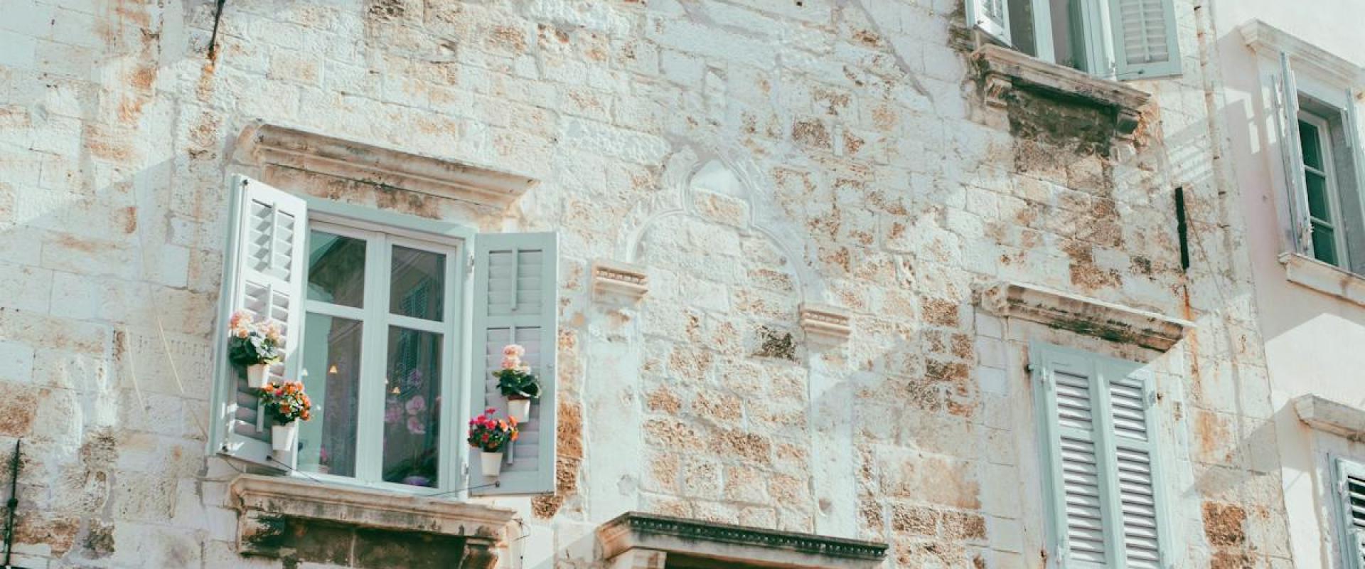 Explore the charming historic architecture of Pula, Croatia with rustic stone buildings and quaint windows.