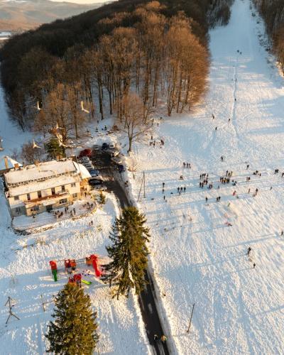 Aerial view of a snowy winter landscape in Daruvar, Croatia, with people enjoying outdoor activities.
