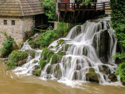 Captivating waterfall next to an old mill in Slunj, showcasing natural beauty and Croatian heritage.