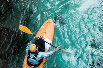 A kayaker paddles through clear turquoise waters, showcasing adventure sports in Croatia.