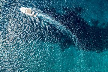 Stunning aerial view of boats along the vibrant coastline of Croatia, capturing the crystal-clear blue water.