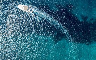 Stunning aerial view of boats along the vibrant coastline of Croatia, capturing the crystal-clear blue water.