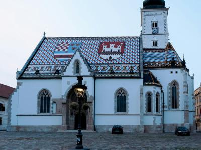 Stunning view of St. Mark's Church in Zagreb's historic square, featuring its vibrant tiled roof at dusk.