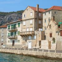 Charming stone buildings along a sunlit Croatian waterfront, perfect for travel inspiration.