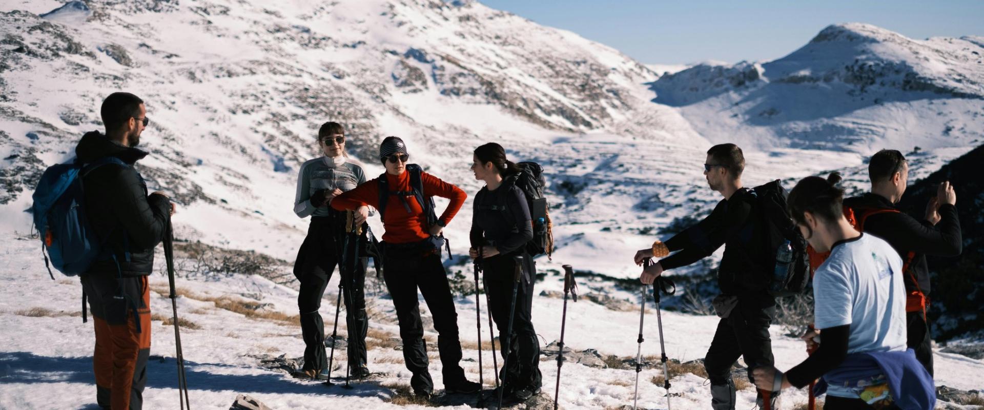 A group of hikers with trekking poles exploring snowy mountains in Croatia during the day.