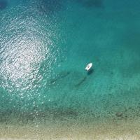 Serene aerial view of a paddleboarder floating on crystal-clear Adriatic waters near Podaca, Croatia.