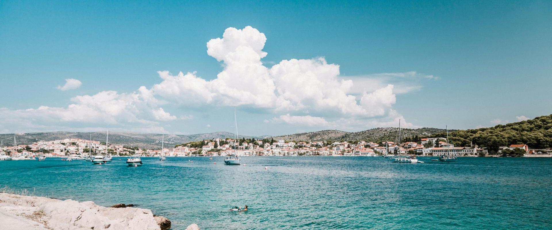 Beautiful view of the Croatian coastline with clear blue water and a charming town in the background.