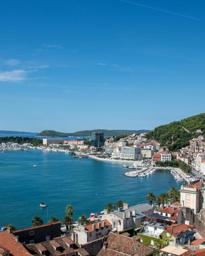 Stunning aerial photo of Split, Croatia showing the coastline, cityscape, and vibrant blue sea on a sunny day.