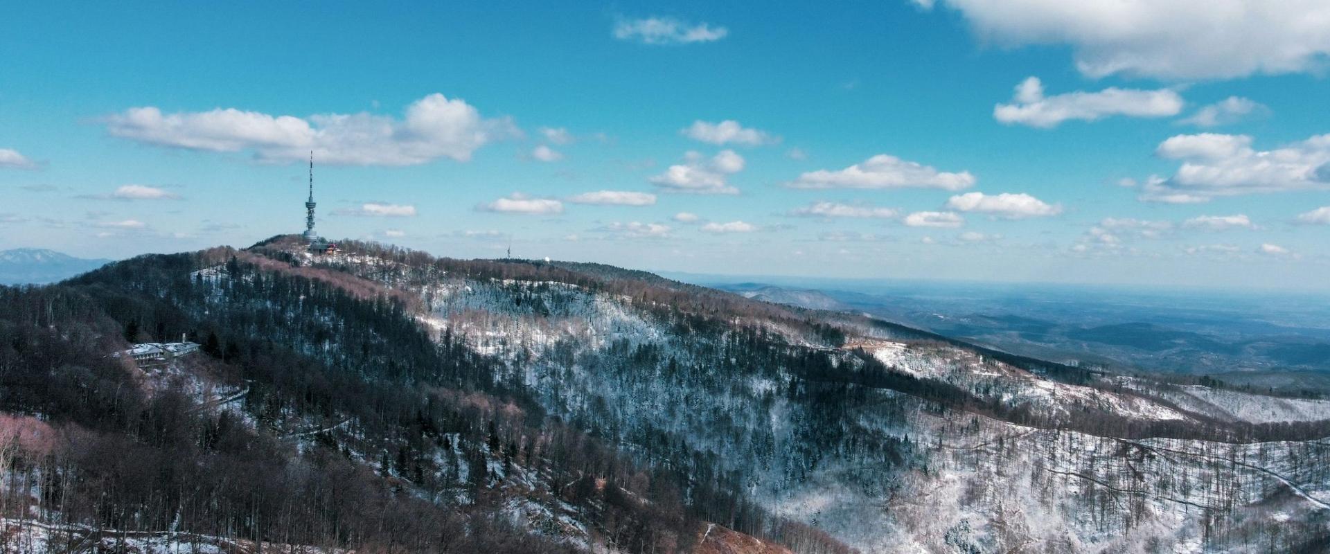 a snowy mountain with a radio tower on top of it