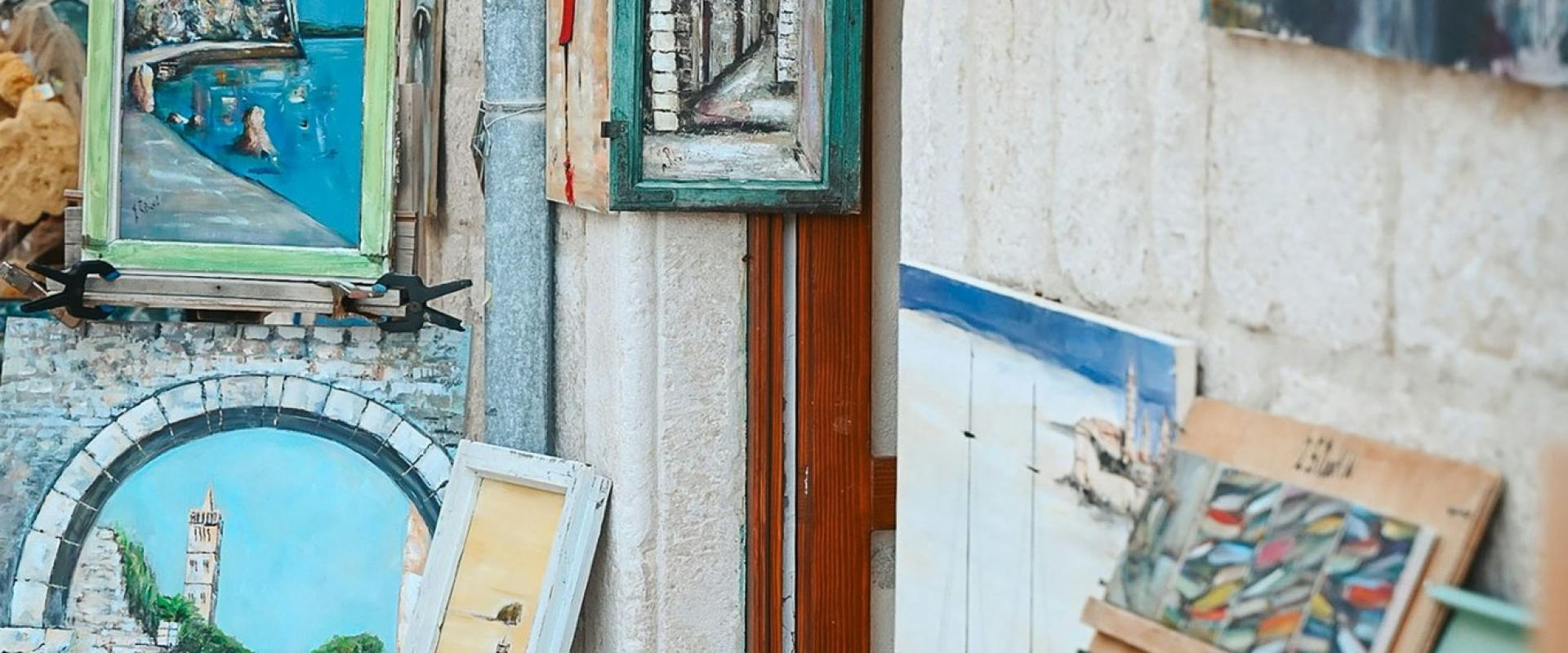 Artwork and prints are displayed outside a building.