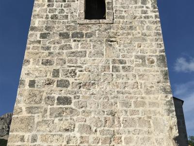 Stone bell tower and facade of the Church of St. Lucy in Jurandvor near Baška, island of Krk