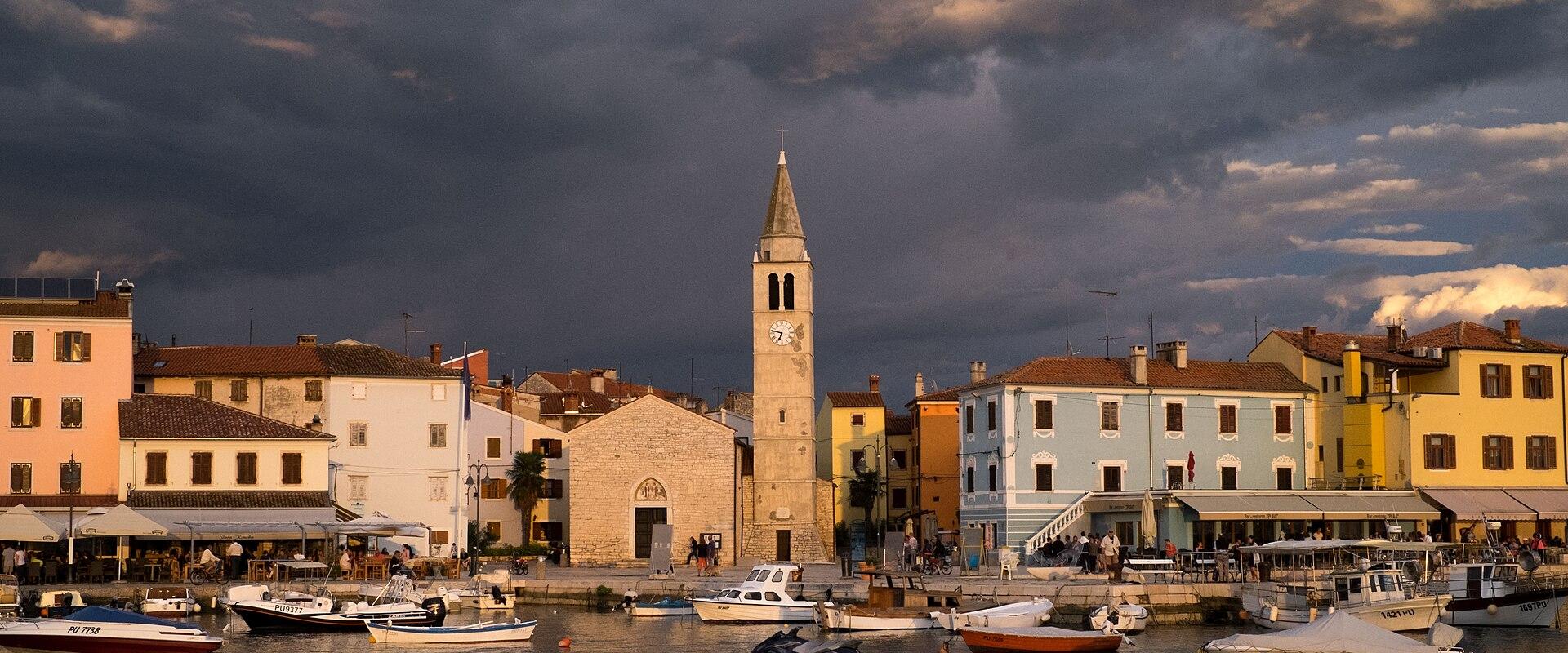 The harbour of Fažana with fishing boats and the church bell tower