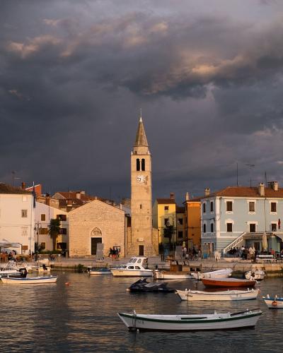 The harbour of Fažana with fishing boats and the church bell tower