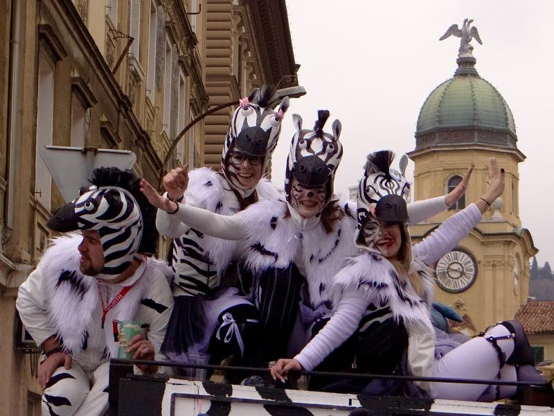 Masked carnival group on a float in front of the City Clock Tower on the Korzo in Rijeka