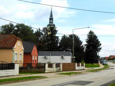 Village street in Dekanovec, Međimurje, with the spire of the Church of All Saints rising above the houses