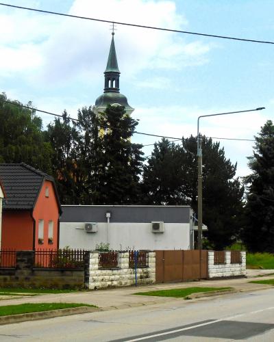 Village street in Dekanovec, Međimurje, with the spire of the Church of All Saints rising above the houses