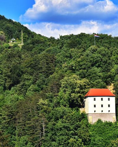 The white tower of the old town fortress of Krapina rising above the forested hill