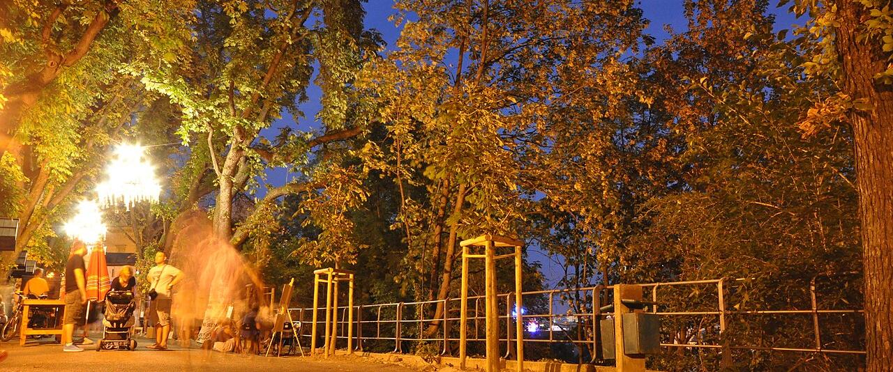 Lamps hanging under the trees of the Strossmayer Promenade in Zagreb's Upper Town at dusk