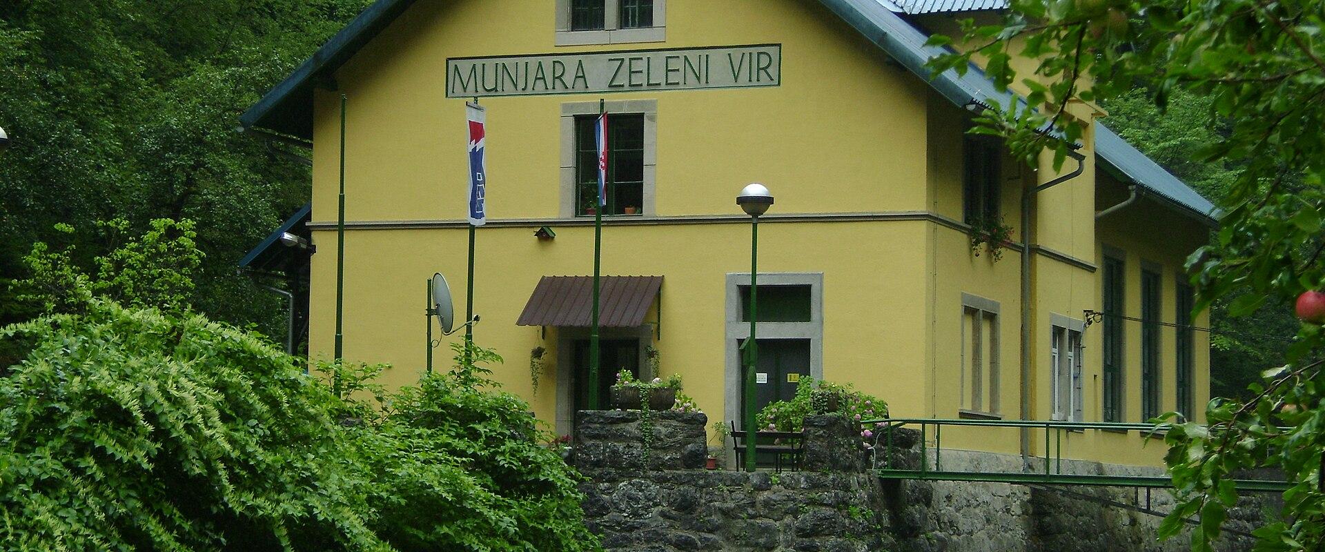 The yellow Munjara Zeleni Vir power station building by the stream