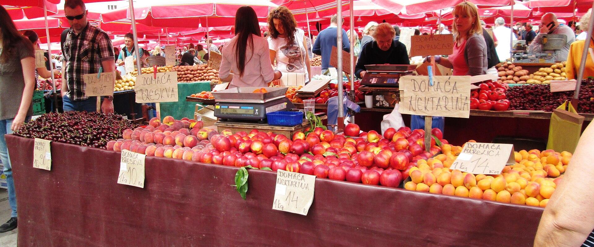 Fruit and vegetable stalls under red umbrellas at Dolac market, Zagreb